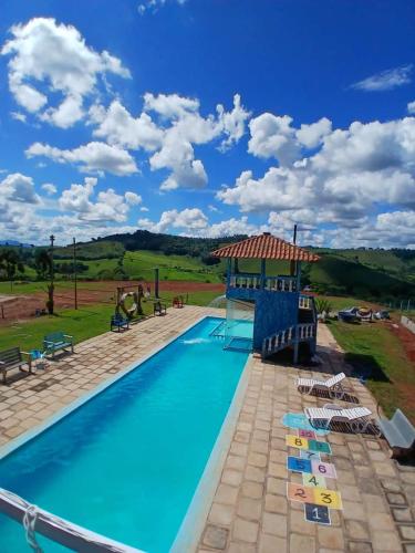 a pool at a resort with a gazebo at Pousada Omirante do Coura in Pouso Alto