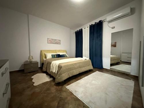 a bedroom with a bed with blue curtains in it at Dora apartment in Tirana