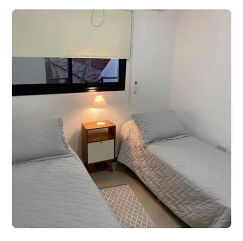 a bedroom with two beds and a table with a lamp at Siloé Bella Vista in Bella Vista