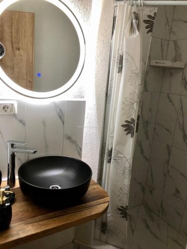 a bathroom with a black sink and a mirror at Mountain View PM in Poiana Mărului