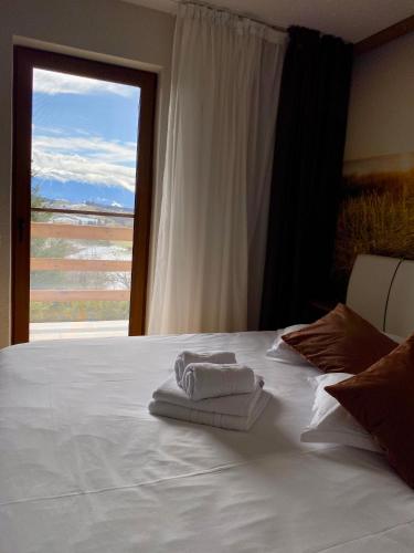 a bedroom with a white bed with a window at Mountain View PM in Poiana Mărului