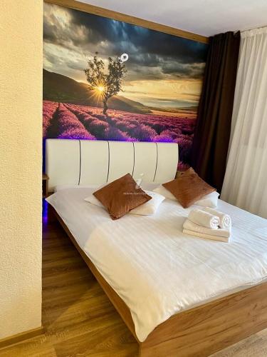a bedroom with a bed with a painting on the wall at Mountain View PM in Poiana Mărului