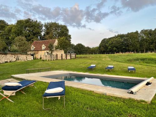 - une piscine avec des chaises longues dans un champ dans l'établissement Les maisons sur la Colline, à Colonard-Corubert