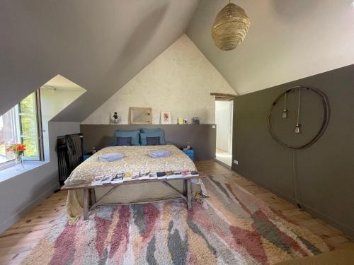 - une chambre avec un lit et un grand tapis dans l'établissement Les maisons sur la Colline, à Colonard-Corubert