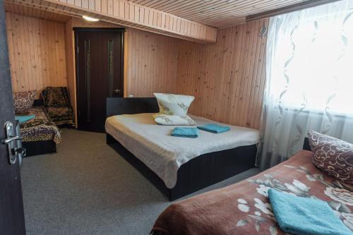 a small room with a bed and a chair in it at Гостьовий дім "У Ані" in Yablunytsya
