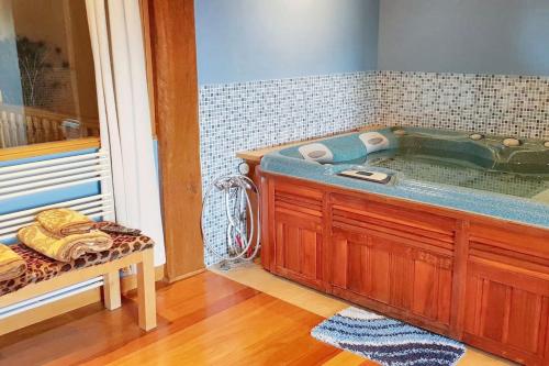 łazienka z wanną ze stołem i ławką w obiekcie Cosy house with jacuzzi in Zugarramurdi w mieście Zugarramurdi