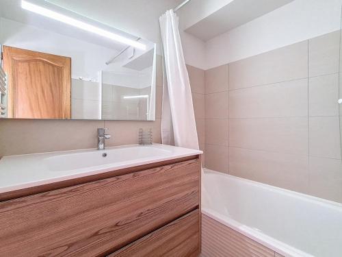 a bathroom with a white sink and a bath tub at Appartement cosy avec mezzanine et balcon, au pied des pistes, Wi-Fi inclus - FR-1-344-825 in Saint-Martin-de-Belleville