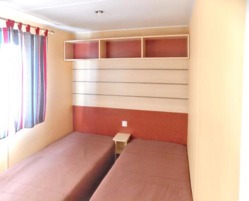 a bedroom with two beds and a wall with shelves at Charming Bungalow in Pataias with Shared Pool in Pataias