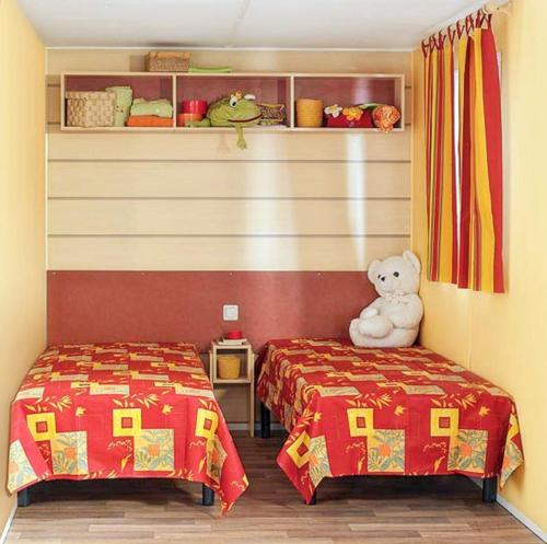 a room with two beds and a teddy bear at Comfortable Bungalow Near Pataias with Shared Pool in Pataias