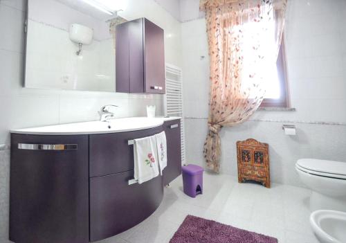 un bagno con lavandino, WC e specchio di Cosy Villa in Ladispoli with Private Pool a Ladispoli