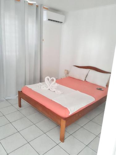 a bed in a room with a red and white bedvisor at Appartement accueillant à Sainte-Anne – 60 m² avec piscine in Sainte-Anne