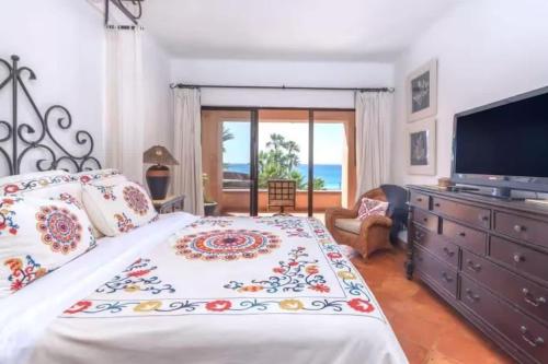a bedroom with a large bed and a television at 2BD Exclusive Cabo Corridor Beach Front Luxury in San José del Cabo