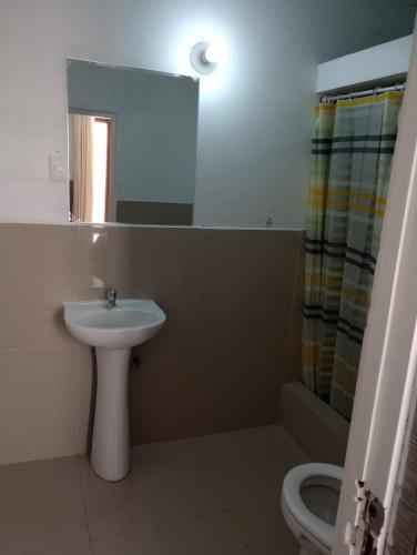 a bathroom with a sink and a toilet and a mirror at Hospedaje Rocha in Ica
