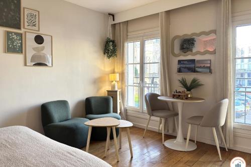 une chambre avec un lit, des chaises et une table dans l'établissement Le Nid de Notre-Dame - Parking, au Havre