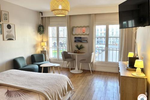 une chambre avec un lit, une table et des chaises dans l'établissement Le Nid de Notre-Dame - Parking, au Havre