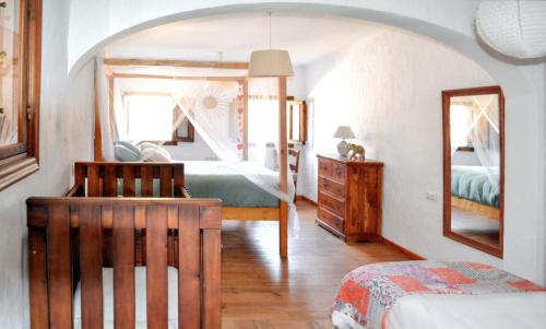a bedroom with a bed and a dresser and a mirror at Spacious House with Private Pool El Soto in El Cañal