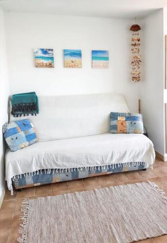 - un canapé blanc dans une pièce avec un tapis dans l'établissement Studio cosy à Saint-Cyprien, vue mer, 22 m², à Saint-Cyprien