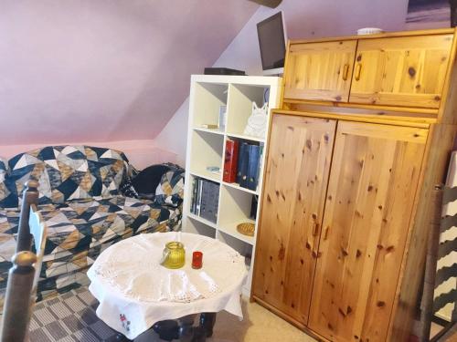 a room with a table and a book shelf at Cozy Apartment in Estinnes – 40 sqm with a fenced garden. in Estinnes-au-Val