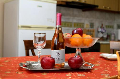 a bottle of wine and a bowl of apples on a table at VILA SOFi in Néa Karyá