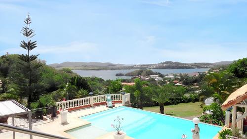 a large swimming pool with a view of the water at Maison accueillante à La Trinité avec piscine partagée 57 m² in La Trinité