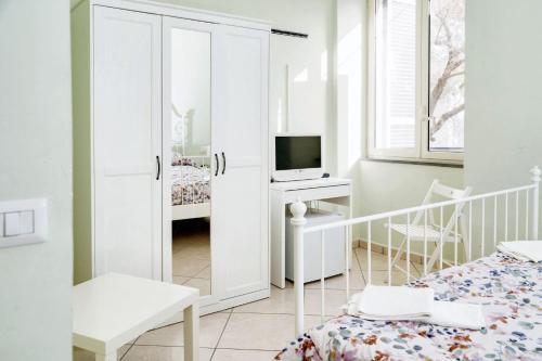 a white bedroom with a bed and a television at Comfortable apartment in Gragnano 45 m² with quiet balcony in Castello