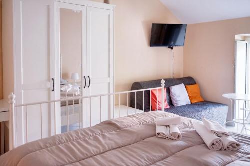 a bedroom with a bed with a chair and a tv at Comfortable apartment in Gragnano 45 m² with quiet balcony in Castello