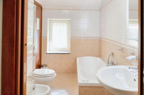 a bathroom with a toilet and a sink and a tub at Comfortable apartment in Gragnano 45 m² with quiet balcony in Castello