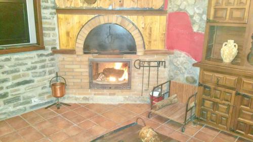 a brick fireplace with a fire in a room at Spacious villa with private pool in La Puebla de Castro in La Puebla de Castro