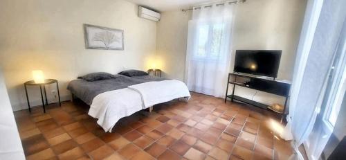 une chambre avec un lit et une télévision à écran plat dans l'établissement Villa charmante à Monteux + piscine, à Monteux