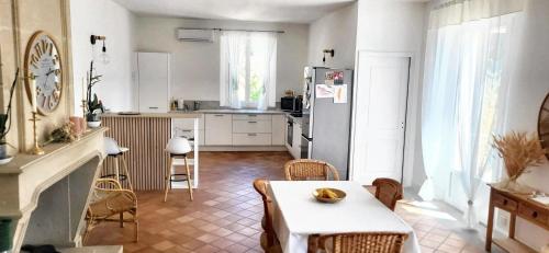 une cuisine avec une table et un réfrigérateur dans l'établissement Villa charmante à Monteux + piscine, à Monteux