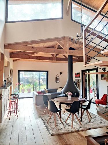 - un salon avec une cheminée, une table et des chaises dans l'établissement Maison spacieuse à Saint-Selve avec jardin et barbecue, 125 m²., à Saint-Selve