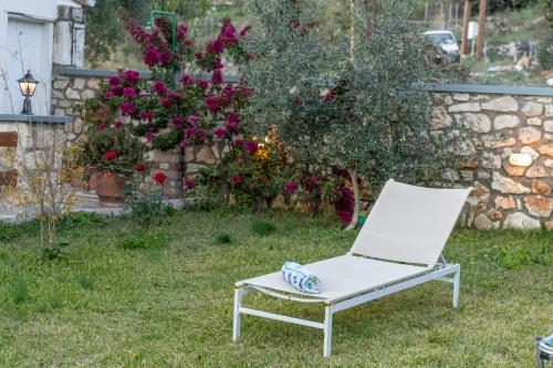 a white chair sitting in a yard with flowers at Villa Aurora in Grizáta