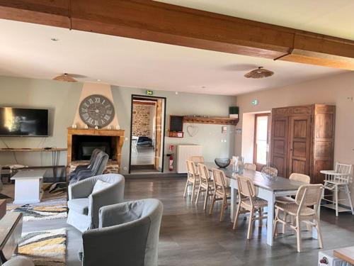 a living room with a table and chairs and a clock at Domaine des Vignes d'Hôtes in Bagnols