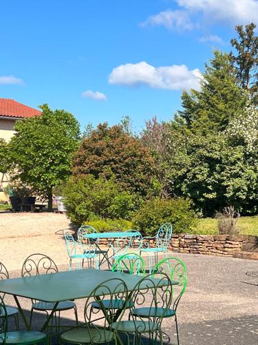 a group of tables and chairs around a green table at Domaine des Vignes d'Hôtes in Bagnols