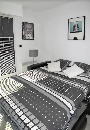 - un lit noir et blanc dans une chambre blanche dans l'établissement Studio charmant à Villers-sur-Mer avec terrasse - 33 m², à Villers-sur-Mer