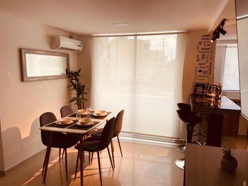 a dining room with a table and chairs and a window at Apartamento Exclusivo - Caribe Campestre Coveñas in Coveñas