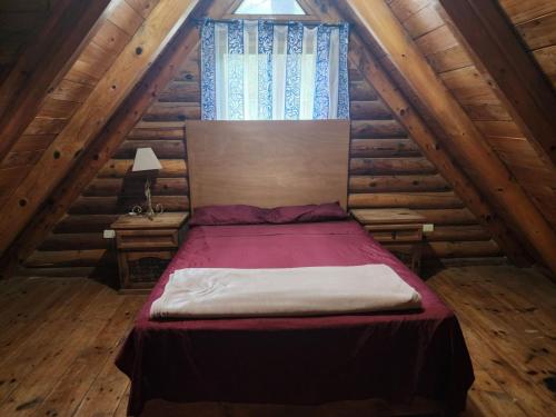 a bedroom with a bed in a log cabin at Cabañas Rincon del Ángel 1 in Ciénaga
