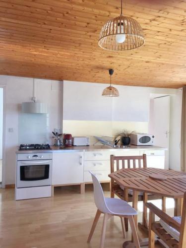 - une cuisine avec une table, une table et des chaises dans l'établissement Appartement charmant avec vue sur la mer à Granville - 55 m², à Granville