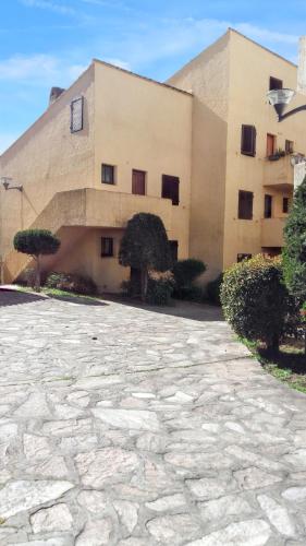 - un bâtiment avec une allée en pierre en face dans l'établissement Appartement élégant à Grosseto-Prugna de 46 m² avec piscine partagée, à Grosseto-Prugna