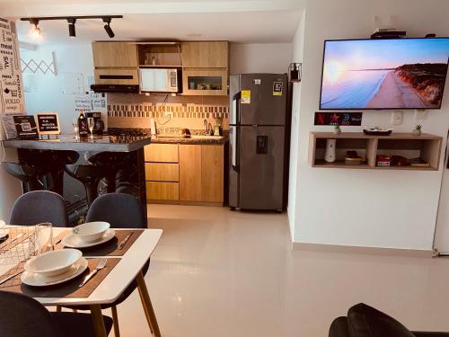 a kitchen with a refrigerator and a table with chairs at Apartamento Exclusivo - Caribe Campestre Coveñas in Coveñas