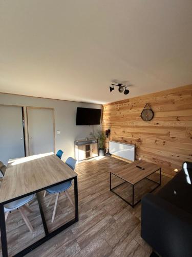 - un salon avec une table et une télévision dans l'établissement Maison au calme à l'orée du bois, à Lunery
