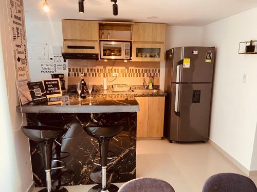 a kitchen with a stainless steel refrigerator and a counter at Apartamento Exclusivo - Caribe Campestre Coveñas in Coveñas