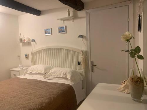a bedroom with a bed and a vase of flowers on a table at CASABARBARA lerici in Lerici