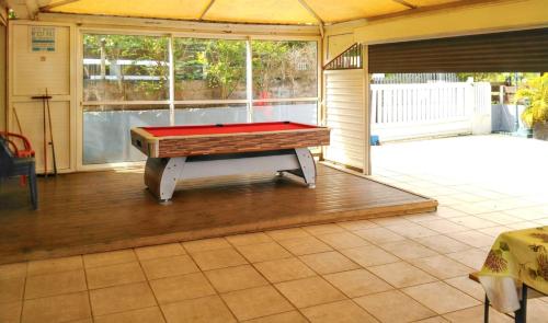 a ping pong table in a room with a patio at Villa exceptionnelle à La Possession avec vue sur la mer in La Possession