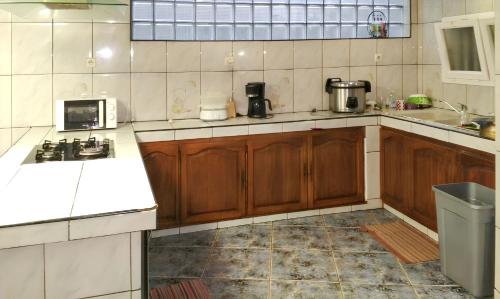 a kitchen with wooden cabinets and a sink and a microwave at Villa exceptionnelle à La Possession avec vue sur la mer in La Possession