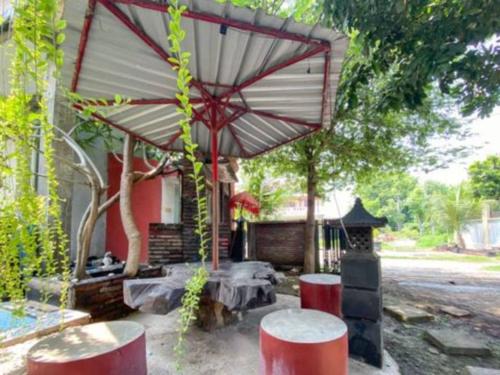 a patio with a table and an umbrella at Surya Guest House in Kanigaran