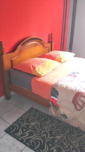 a bed with a wooden headboard in a room at Villa exceptionnelle à La Possession avec vue sur la mer in La Possession