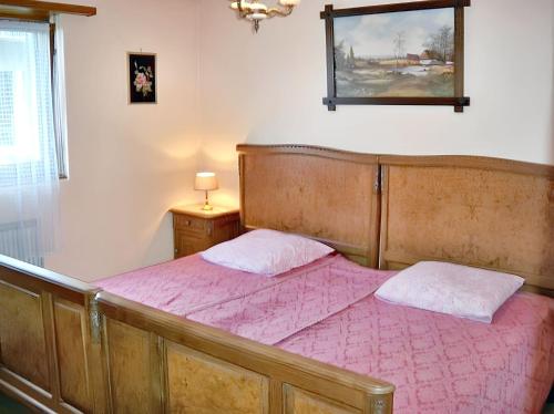 a bedroom with a bed with a pink comforter at Appartement charmant à Jebsheim avec terrasse et jardin in Jebsheim