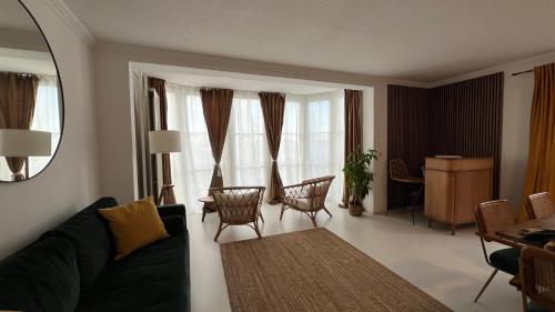 a living room with a couch and a table and chairs at 8 Personen I BBQ I Sunset in Herrsching am Ammersee