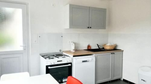 a kitchen with a stove and a white stove top oven at Maison cosy à Pontorson avec jardin clos et terrasse in Pontorson